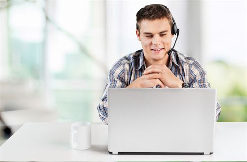 Technicien support au casque devant son ordinateur